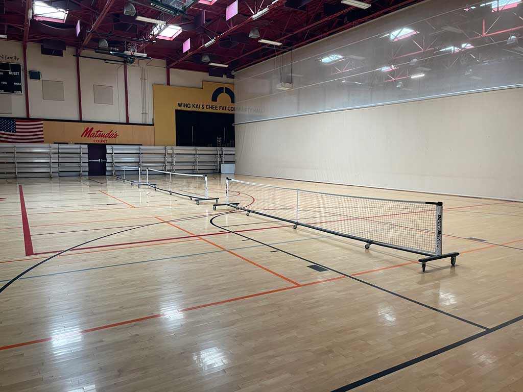 Pickleball courts with a partition separating the other courts.